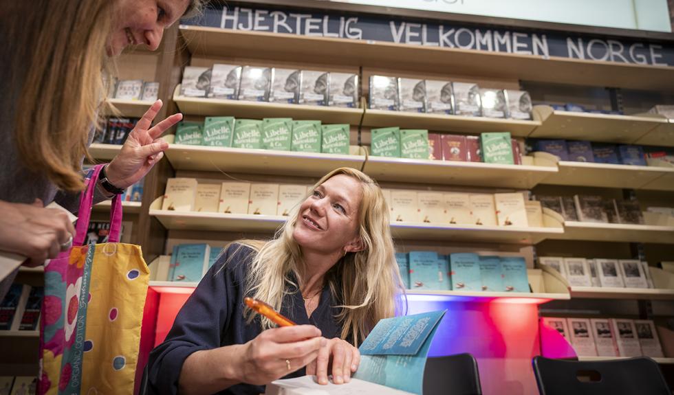 Forfatter Maja Lunde signerer den tyske oversettelsen av boken «Bienes verden» etter et bokbad i bokhandelen Ludwig i Köln, der blant andre kronprinsparet kom innom med Litteraturtoget fra Berlin. Foto: Heiko Junge / NTB scanpix